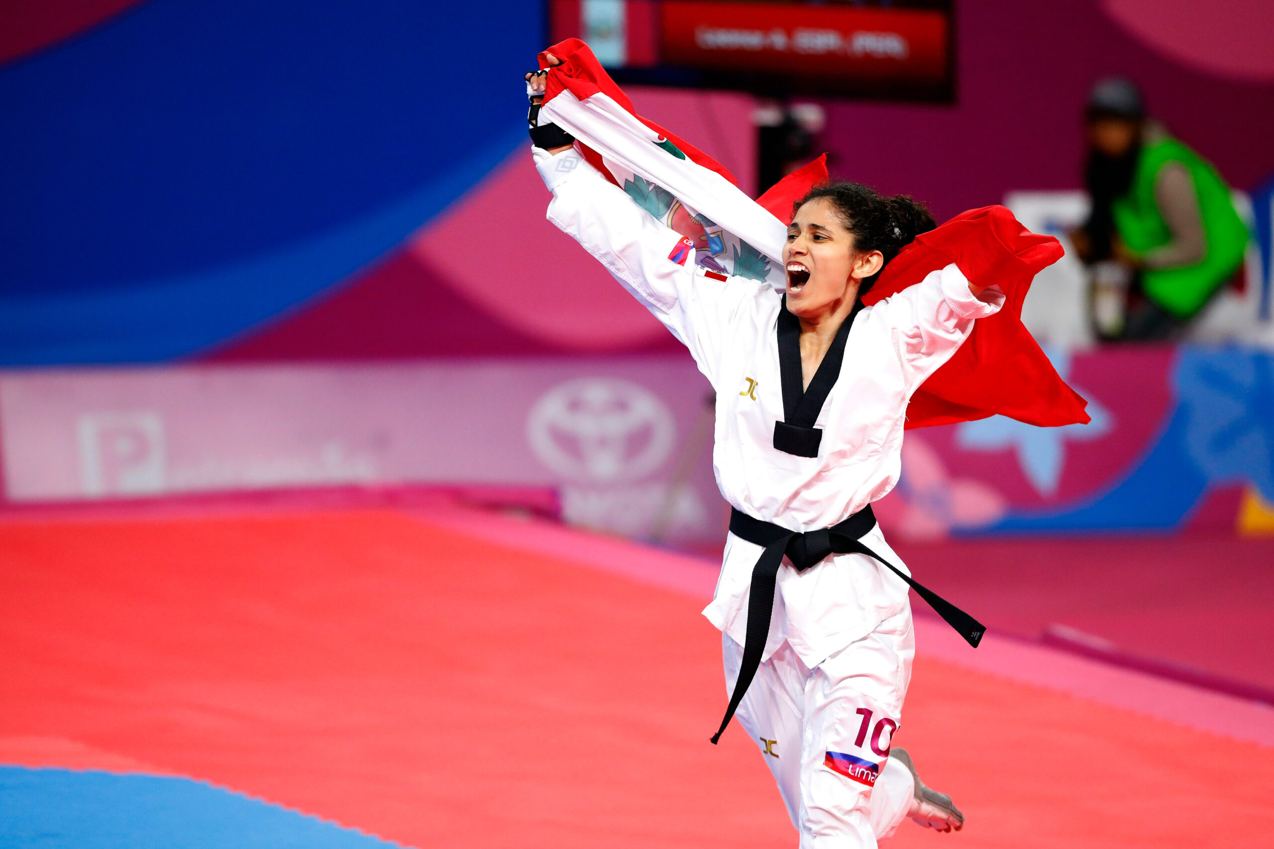 atleta de Taekwondo peruana celebrando con la bandera
