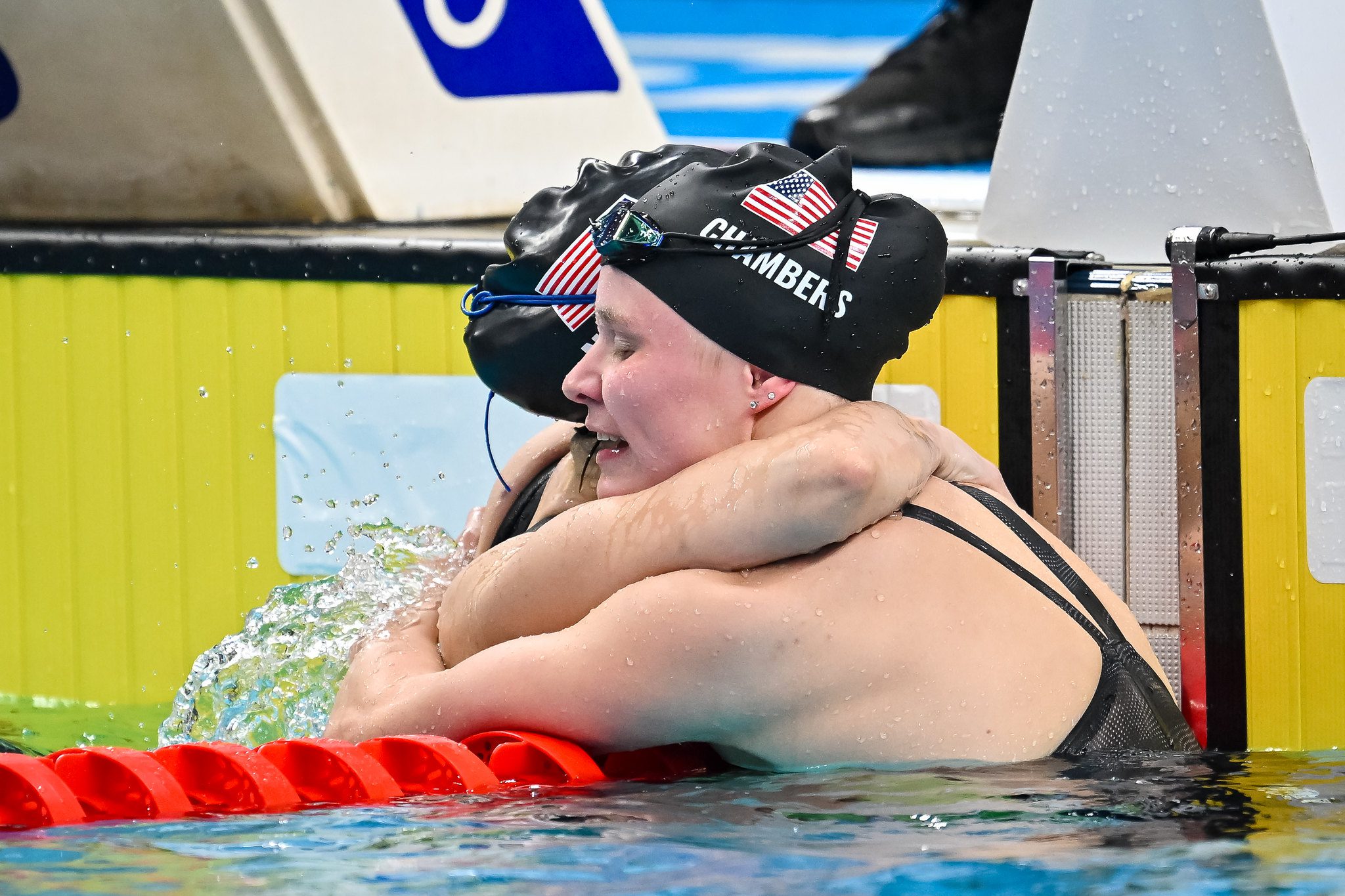 En la foto: dos norteamericanas abrazándose en la piscina tras cerrar su participación en competencia.