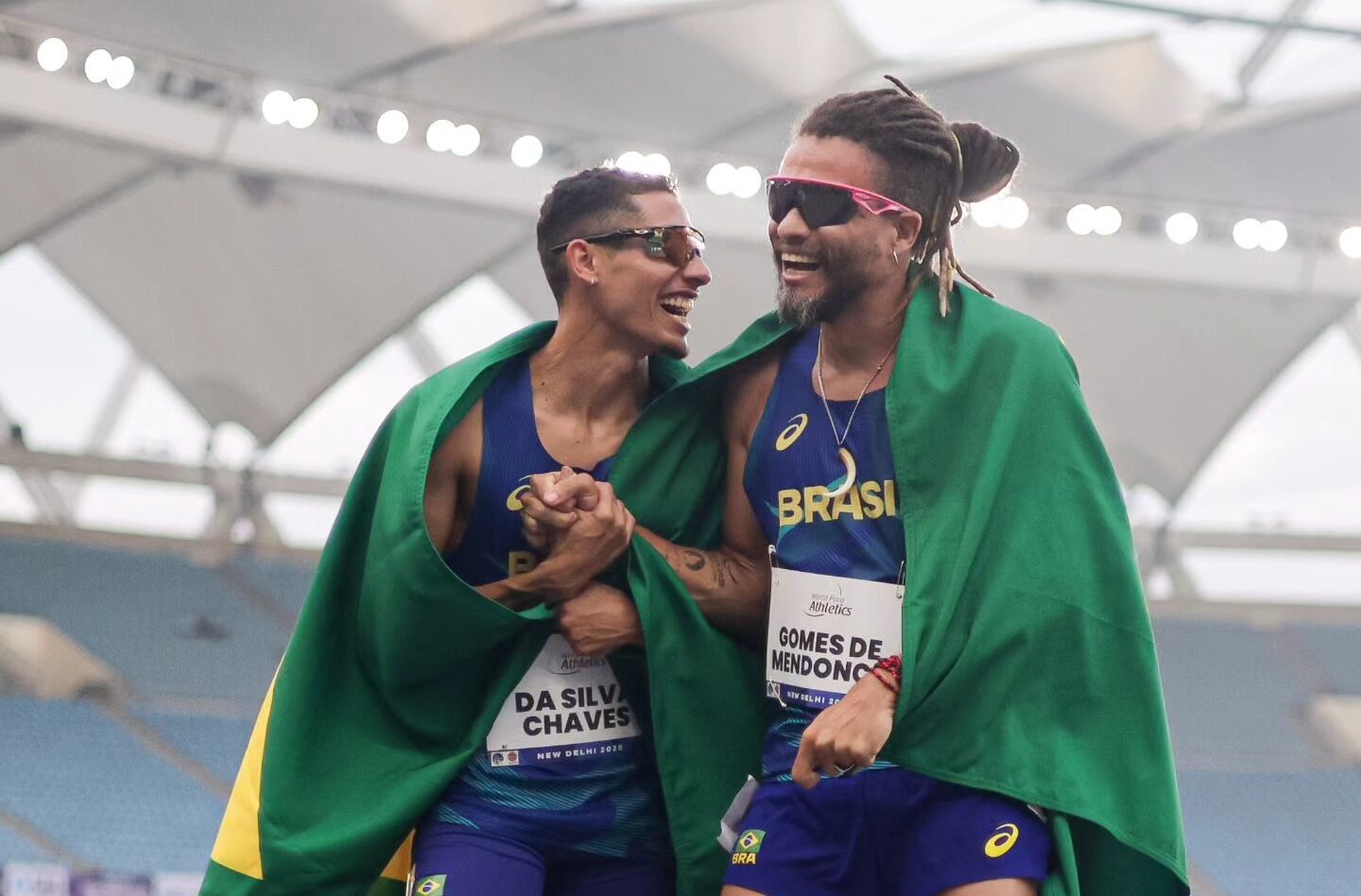 En la foto: dos para atletas brasileros, con su bandera, post competencia sonriendo.