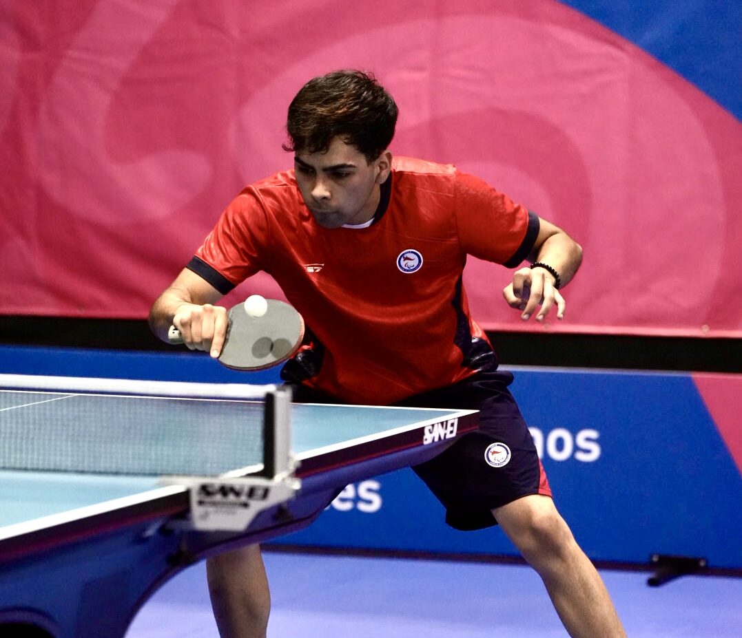 En la foto de ve un tenismesista pegándole a la pelota.