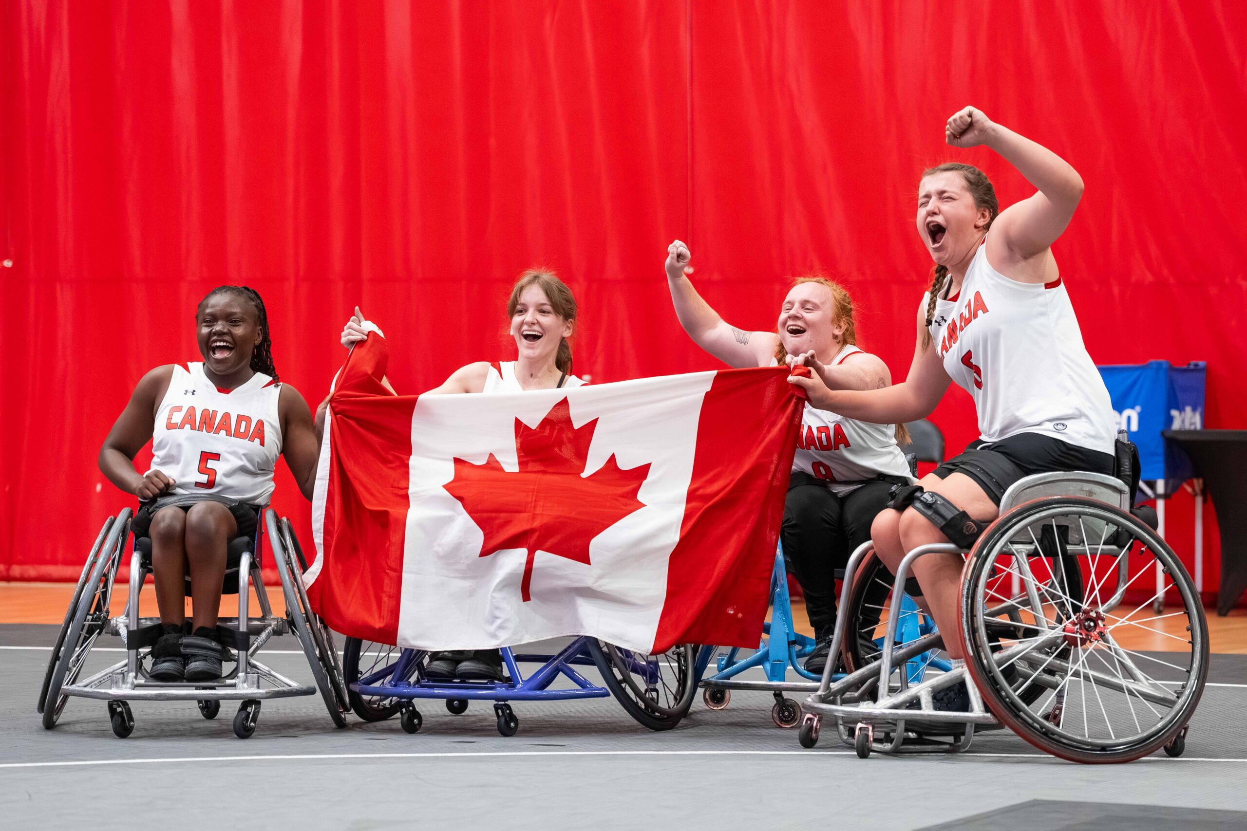En la foto: team canadá en silla de ruedas celebrando con su bandera nacional.